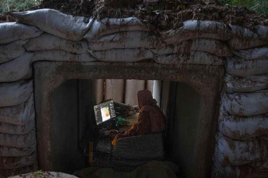 A Thai Buddhist monk uses his computer while taking shelter in Buriram province, Thailand, Tuesday, Dec. 9, 2025, after he fled clashes between Thai and Cambodian soldiers.