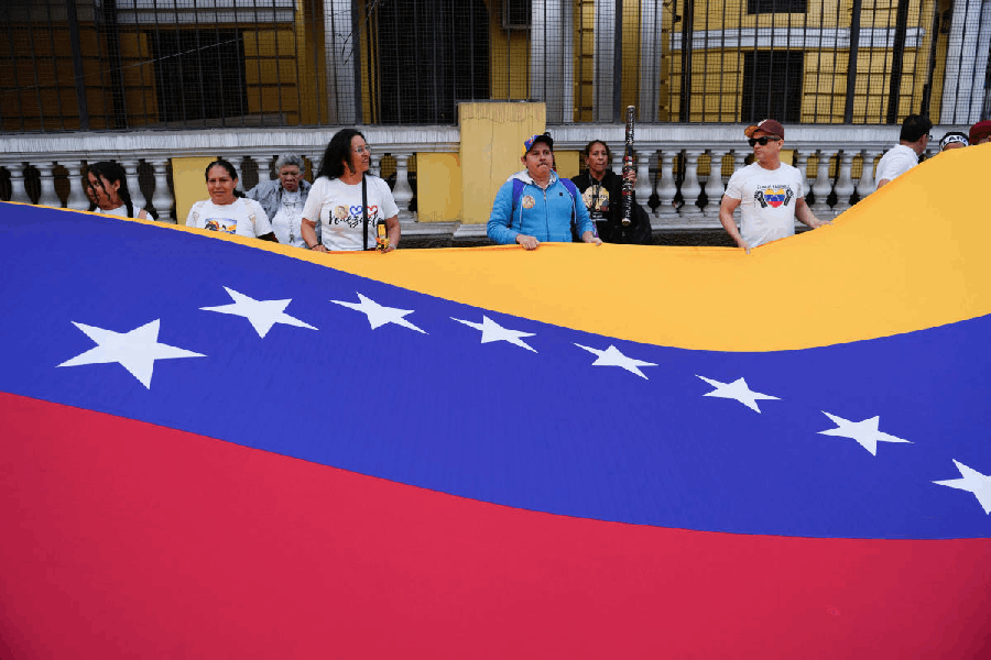 Supporters of Venezuelan opposition leader Maria Corina Machado hold a giant Venezuelan flag, as they join a global march to celebrate her Nobel Peace Prize, in Lima, Peru.