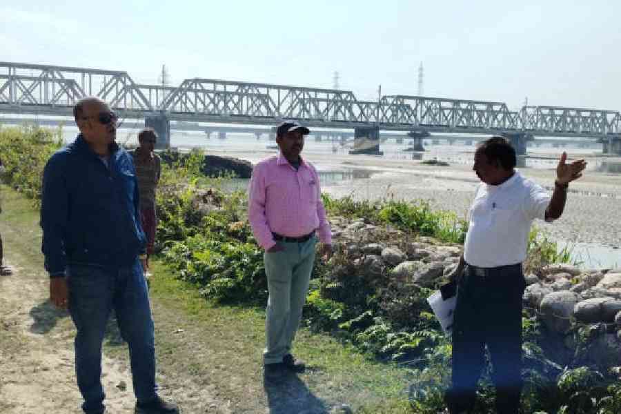 Officials of the state fisheries department visit the banks of the Teesta at Domohoni where dead fish were found floating on Tuesday.  Picture by Biplab Basak