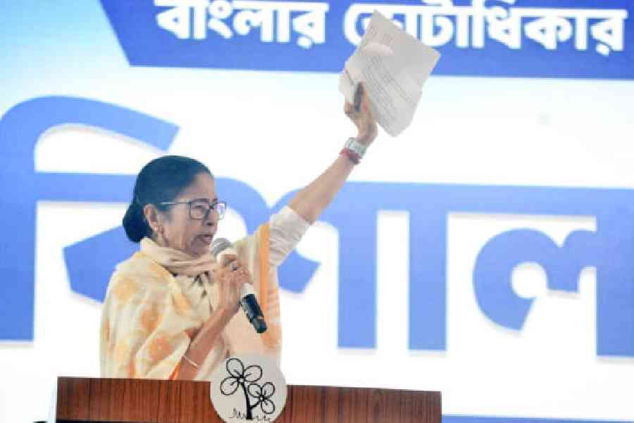 Chief minister Mamata Banerjee holds up a piece of paper that she tore up at the public meeting on the Raasmela Ground in Cooch Behar on Tuesday. Picture by Main Uddin Chisti