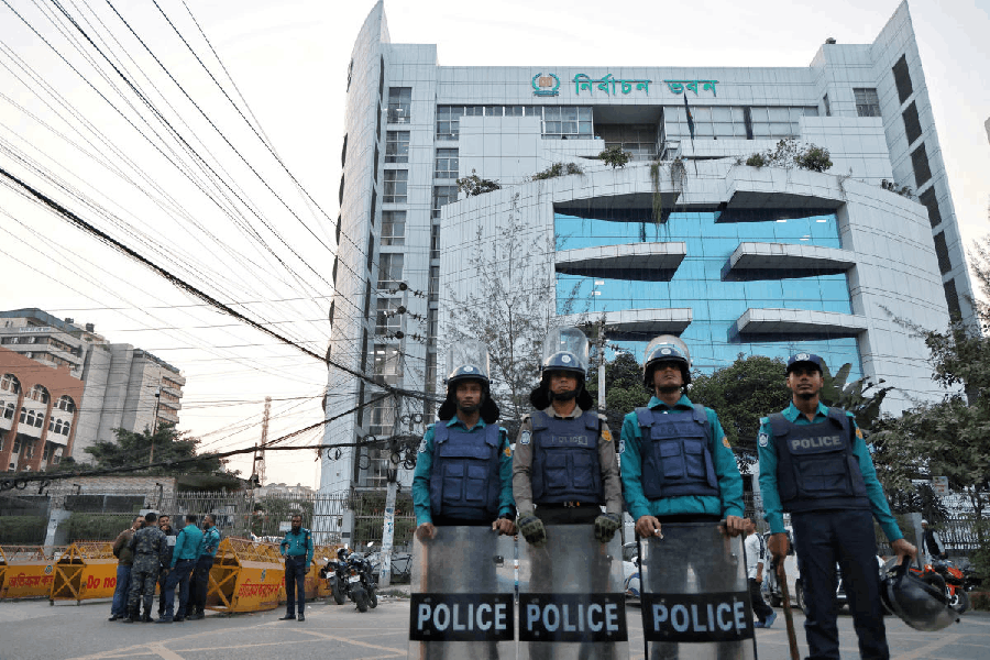 Policemen stand guard in front of the Bangladesh Election Commission office ahead of the expected general election schedule announcement in Dhaka, Bangladesh, December 11, 2025.