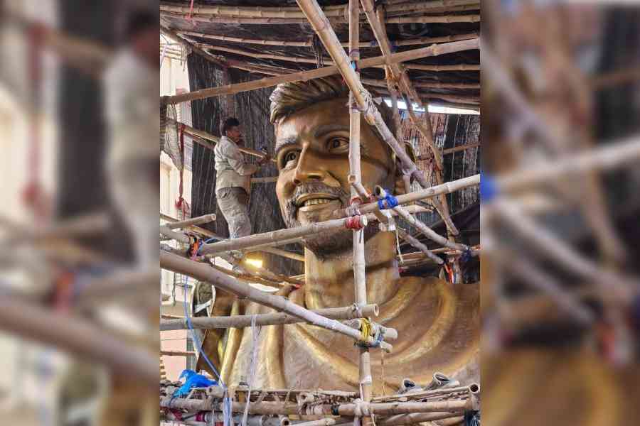 An artist puts finishing touches to Messi’s face in a garage space in Sreebhumi on December 4. Pictures by Sudeshna Banerjee