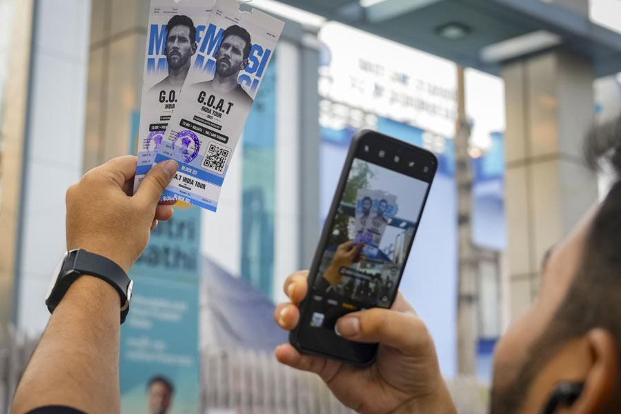 A fan clicks photos of tickets for Lionel Messi's 'GOAT Tour India 2025' at the Vivekananda Yuba Bharati Krirangan stadium, in Kolkata, Wednesday, Dec. 10, 2025.