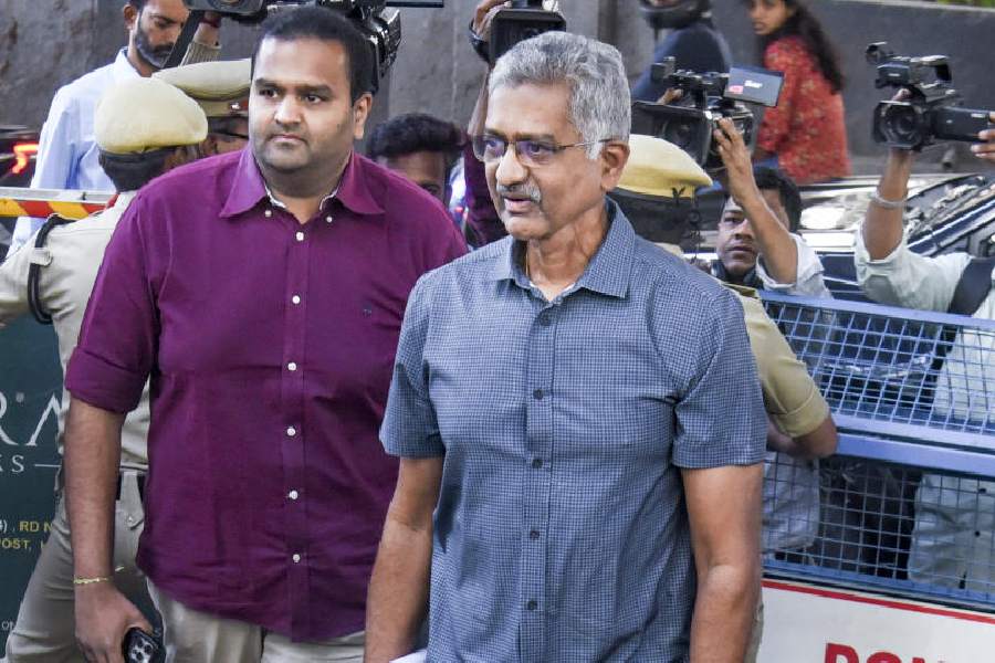 Former Telangana Special Intelligence Bureau (SIB) chief T Prabhakar Rao, right, who is an accused in the phone-tapping case, arrives to surrender before police a day after the Supreme Court issued an order, at Jubilee Hills police station, in Hyderabad, Friday, Dec. 12, 2025.