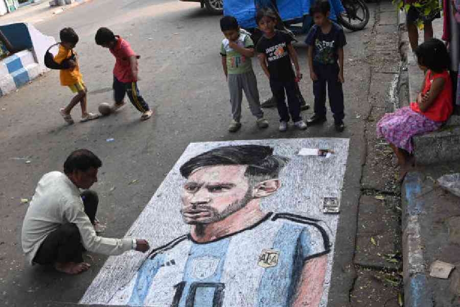Artist Swapan Das draws a portrait of Messi on Mahim Halder Street in Kalighat on Friday. (Sanat Kr Sinha)