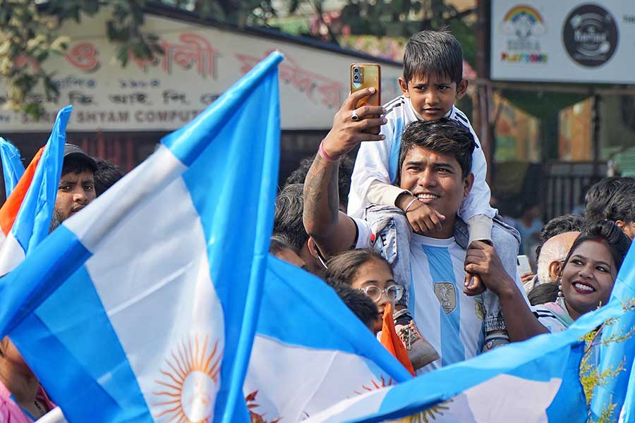 A young fan on his father’s shoulder looks on as people make their best attempt at getting pictures