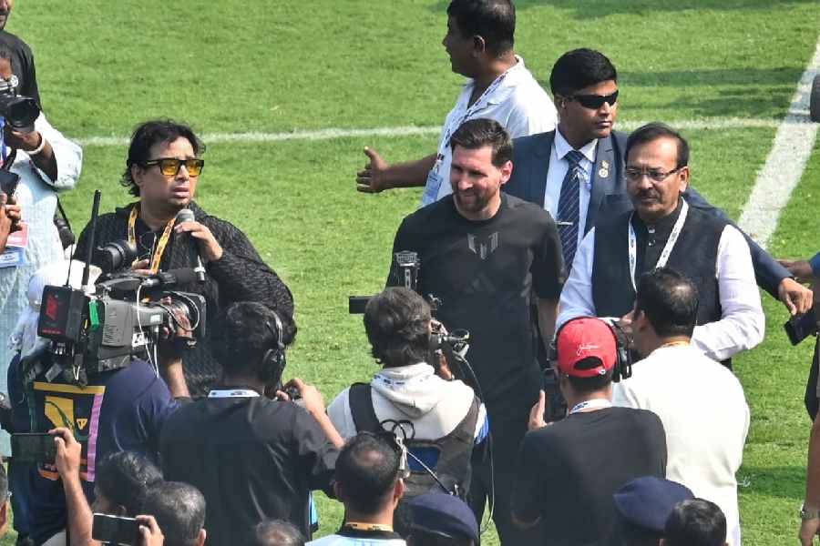 Lionel Messi (Centre) with organiser Satadru Dutta (L) and state sports minister Aroop Biswas (R)