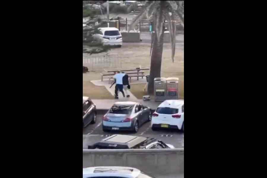 A screenshot shows Ahmed al-Ahmed (in white T-shirt) tackle one of the shooters at Sydney’s Bondi Beach