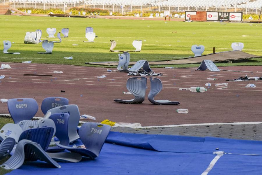 Broken plastic seats and water bottles lie scattered on the track and field in the aftermath of chaos during an event featuring Argentine football icon Lionel Messi, at Salt Lake Stadium, in Kolkata, Sunday, Dec. 14, 2025.