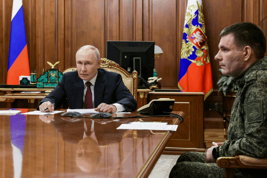 Russian President Vladimir Putin, left, holds a call with military leaders on the Ukraine battlefield situation together with Denis Pirogov, right, a Russian army brigade commander, at the Kremlin in Moscow, on Thursday, Dec. 11, 2025.