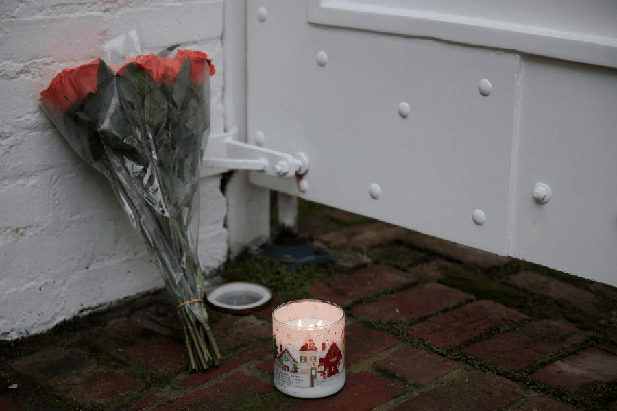 A candle and flowers are placed at the entrance of the Reiner household, where actor-director and political activist Rob Reiner and his wife were found dead, in Los Angeles, California, U.S., December 15, 2025.