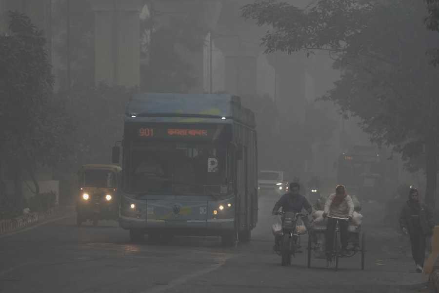 Vehicles make their way through smog in Delhi on Sunday.