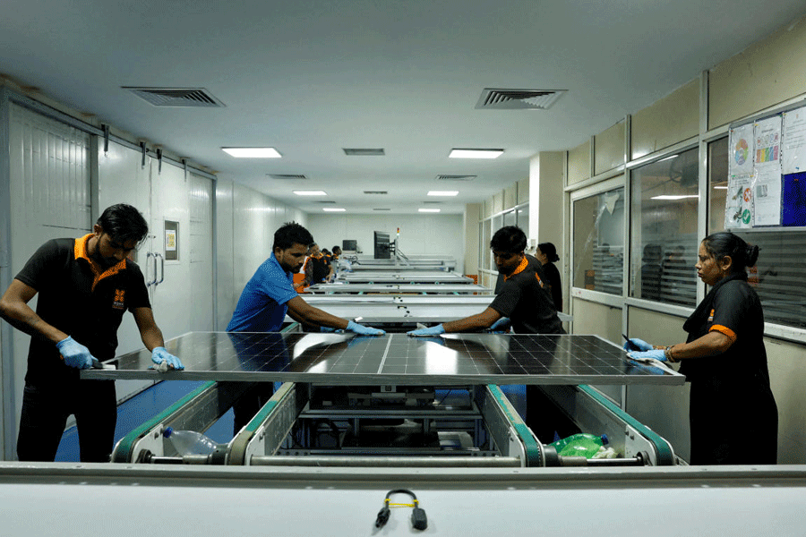 FILE PHOTO: Technicians work on the assembly line in a solar manufacturing hub in Greater Noida, on the outskirts of New Delhi India, October 23, 2024.