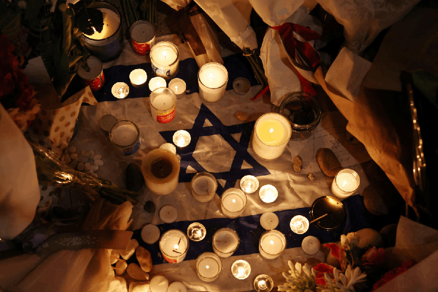 An Israeli flag lies amongst candles left during a vigil honouring the victims of a shooting at Jewish holiday celebration on Sunday at Bondi Beach, in Sydney, Australia, December 16, 2025.