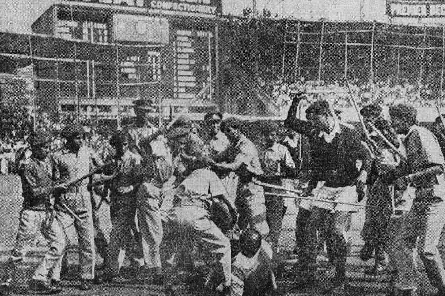 Police and members of the Home Guard beating an old man during India vs West Indies cricket match disturbance in Eden Gardens Stadium.