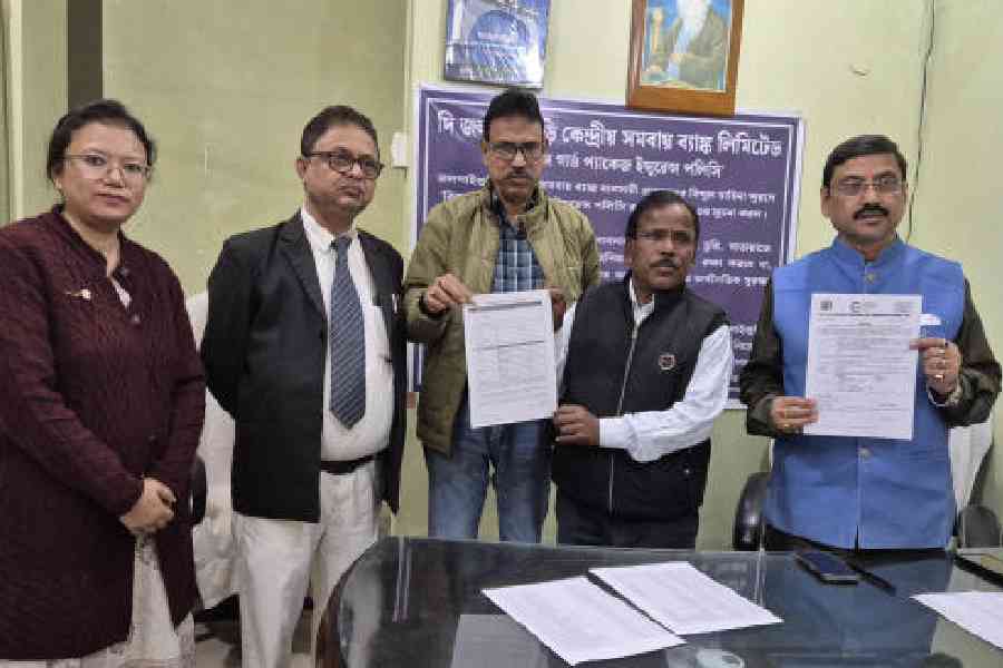Sourav Chakraborty (in blue vest), the chairman of Jalpaiguri Central Cooperative Bank, launches the new insurance policy for small and medium traders with others at the bank headquarters in Jalpaiguri on Tuesday. Picture by Biplab Basak