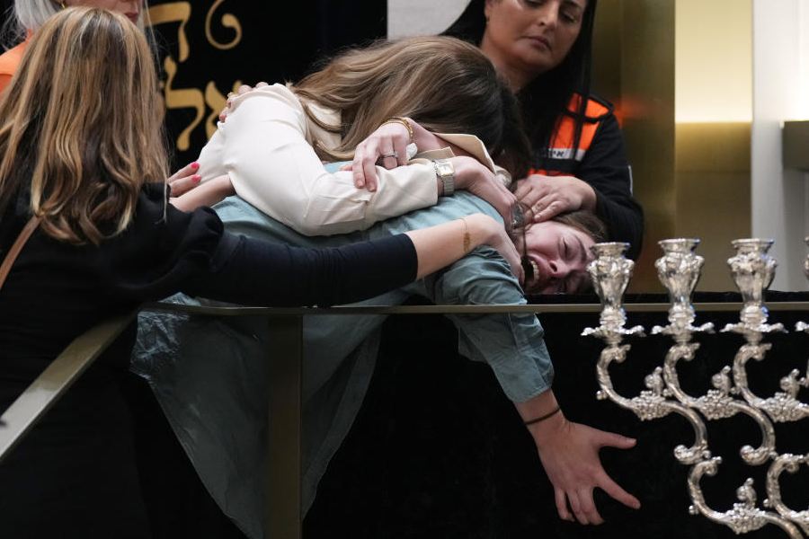 Family react at the coffin of Rabbi Eli Schlanger, a victim in the Bondi Beach mass shooting, during his funeral at a synagogue in Bondi on Wednesday, Dec. 17, 2025, in Sydney, Australia.