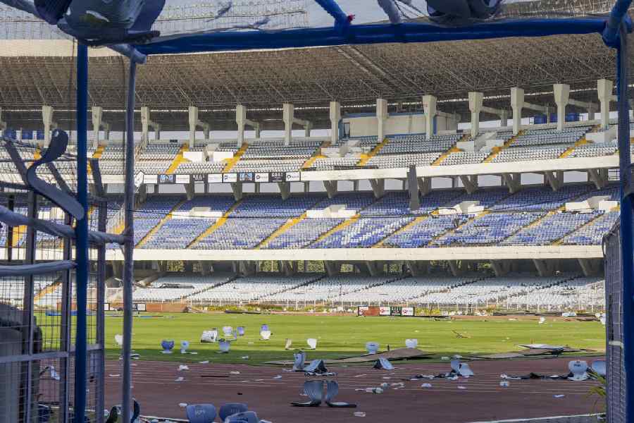 Broken plastic seats and water bottles lie scattered on the track and field in the aftermath of chaos during an event featuring Argentine football icon Lionel Messi, at Salt Lake Stadium, in Kolkata, Sunday, Dec. 14, 2025.