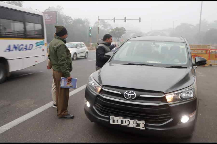 Traffic police personnel stop a vehicle for document verification at the Delhi-Noida Chilla Border, in New Delhi, Thursday, Dec. 18, 2025.