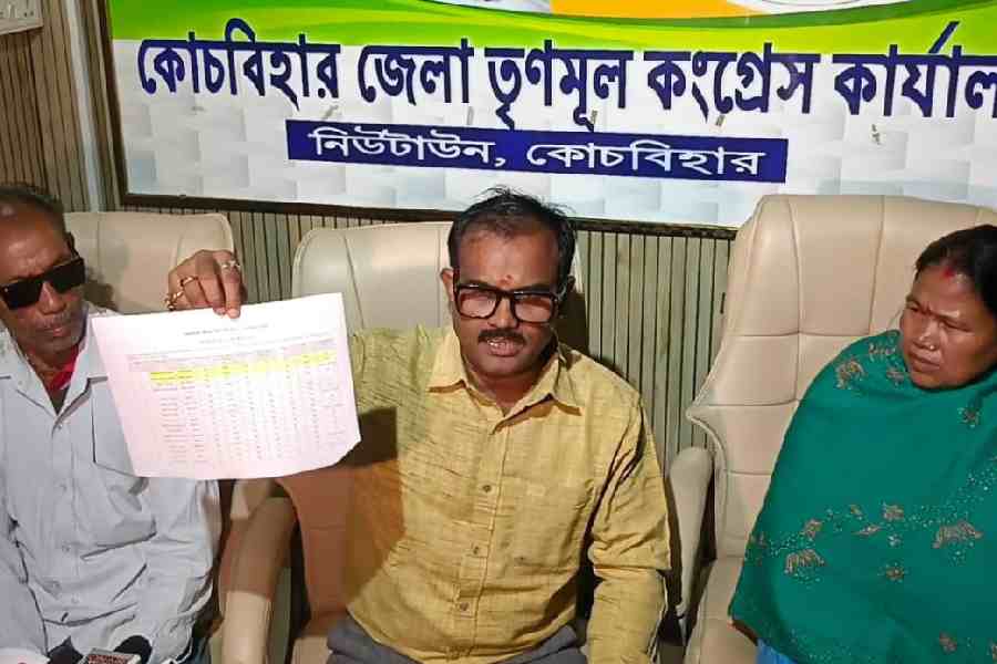 Cooch Behar Trinamool president Abhijit De Bhowmik (centre) on Wednesday holds up the draft roll that shows Ashwini Adhikari and his wife Shivani (flanking the Trinamool leader) as dead.