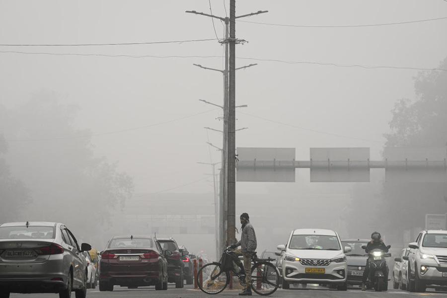 Commuters at a traffic signal on a foggy winter morning, in New Delhi, Thursday, Dec. 18, 2025.