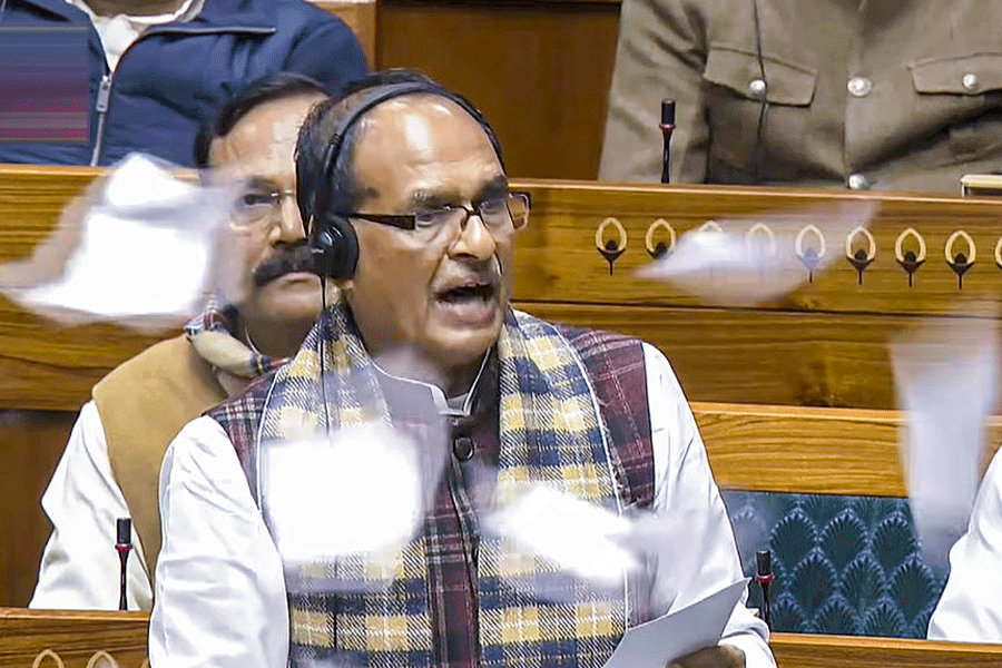 Union Minister Shivraj Singh Chouhan speaks in the Lok Sabha as opposition members throw papers in protest during the Winter session of Parliament, in New Delhi, Thursday, Dec. 18, 2025.