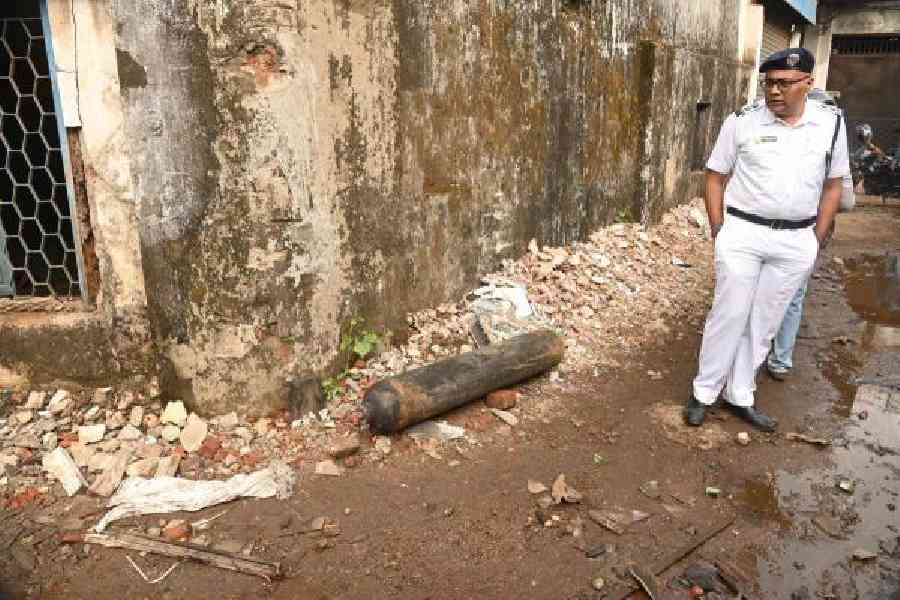 A policeman stands near one of the oxygen cylinders that flew out of the warehouse and landed in the neighbourhood during the blaze at Kankurgachi early on Thursday.            Picture by Bishwarup Dutta