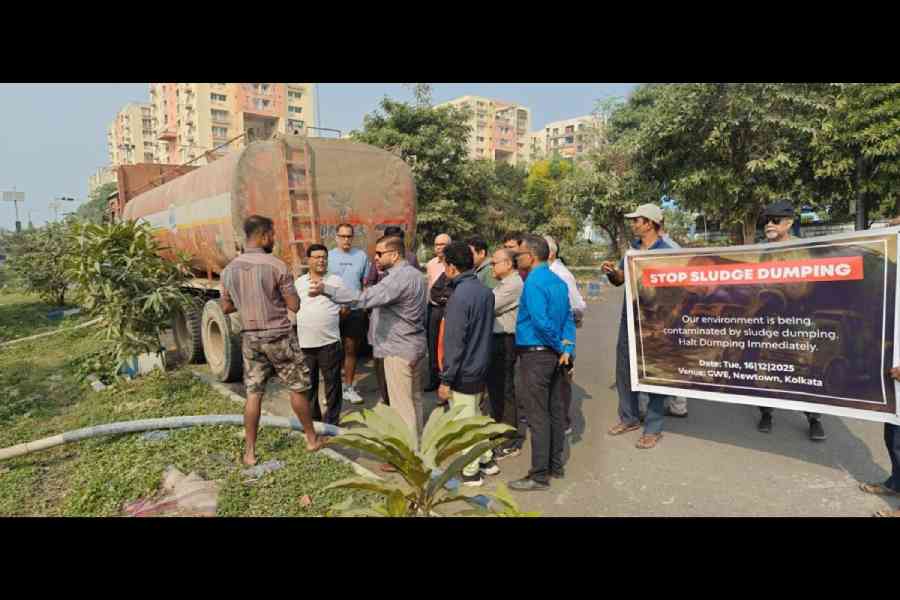 Resents of Greenwood Elements speak to a labourer dumping slurry in a field beside the housing complex in the course of a protest on Tuesday