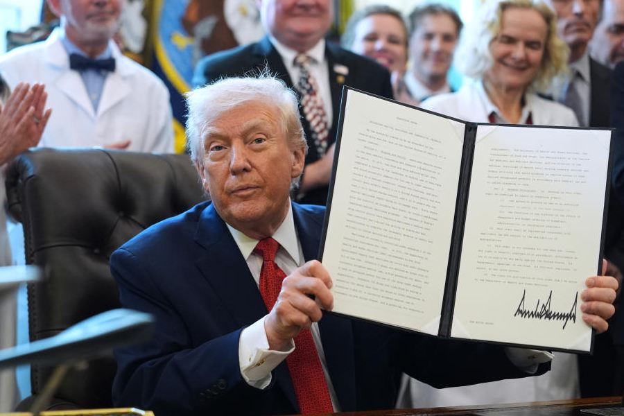 President Donald Trump displays an executive order reclassifying marijuana as a less dangerous drug in the Oval Office of the White House, Thursday, Dec. 18, 2025, in Washington.