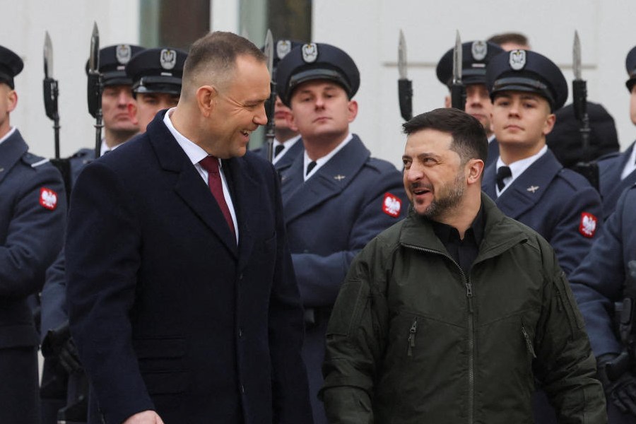 Polish President Karol Nawrocki and Ukrainian President Volodymyr Zelenskiy chat after inspecting a guard of honour during a welcoming ceremony at the courtyard of the Presidential Palace in Warsaw, Poland, December 19, 2025.