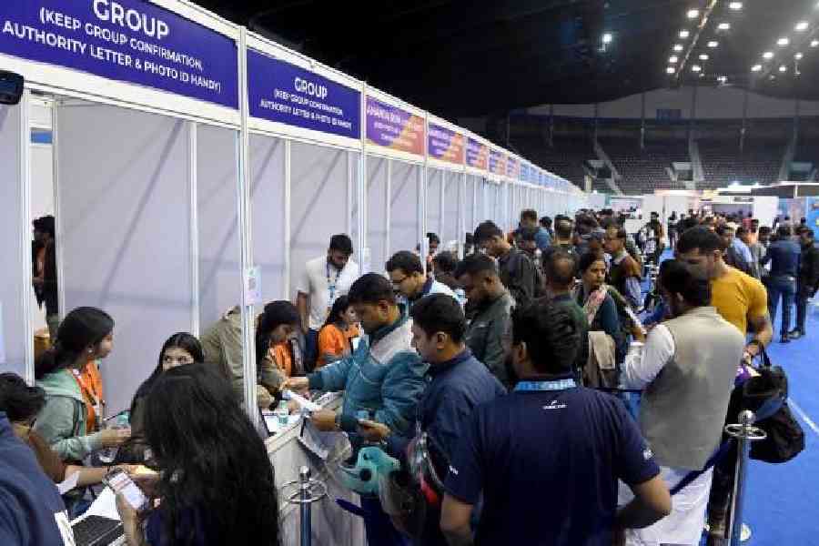 Participants rush to collect runner bibs at Netaji Indoor Stadium on Friday. Picture by Sanat Kr Sinha