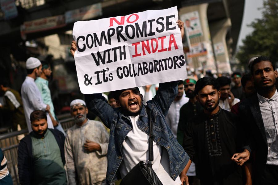 A protester holds a placard and shout slogans during a protest following overnight attacks and vandalism after the death of a prominent activist, who was shot by an assailant a week ago, in Dhaka, Bangladesh, Friday, Dec. 19, 2025.
