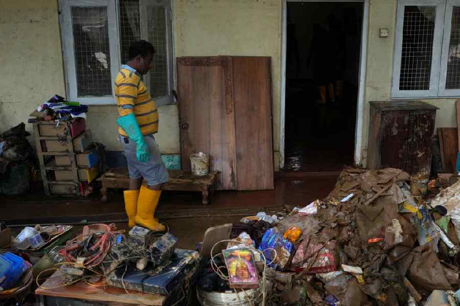 A man moves past damaged household goods after floods following Cyclone Ditwah in Kandy, Sri Lanka