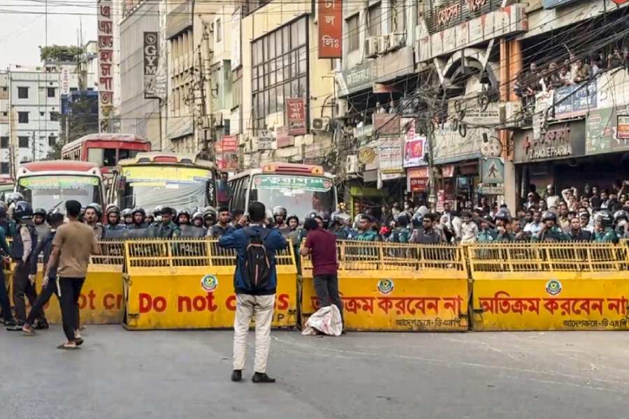 Dhaka: Security personnel stand behind barricades to stop protesters as Bangladeshi groups gather for a march following the MEA's summoning of the Bangladesh High Commissioner over a threat to the Indian mission, in Dhaka, Bangladesh, Wednesday, Dec. 17, 2025