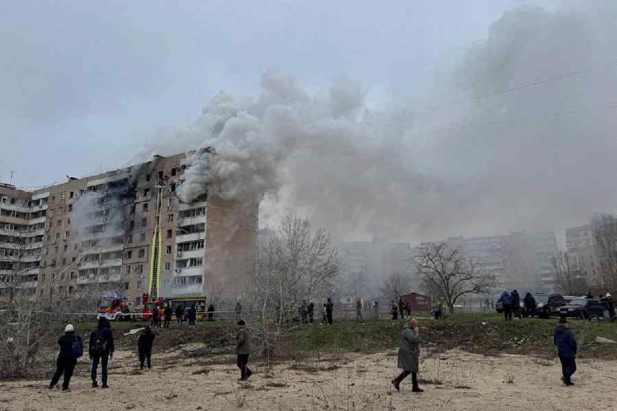 Residents walk in front of an apartment building hit by a Russian air strike, amid Russia's attack on Ukraine, in Zaporizhzhia, Ukraine December 17, 2025.
