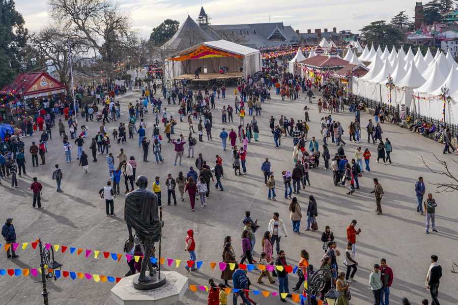 Tourists take a stroll on a winter day, in Shimla, Sunday, Dec. 21, 2025.