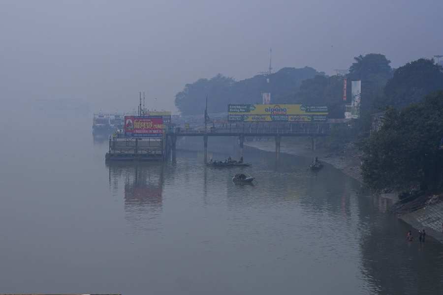 Boats remain anchored on the River Ganga on a foggy winter morning, in Kolkata