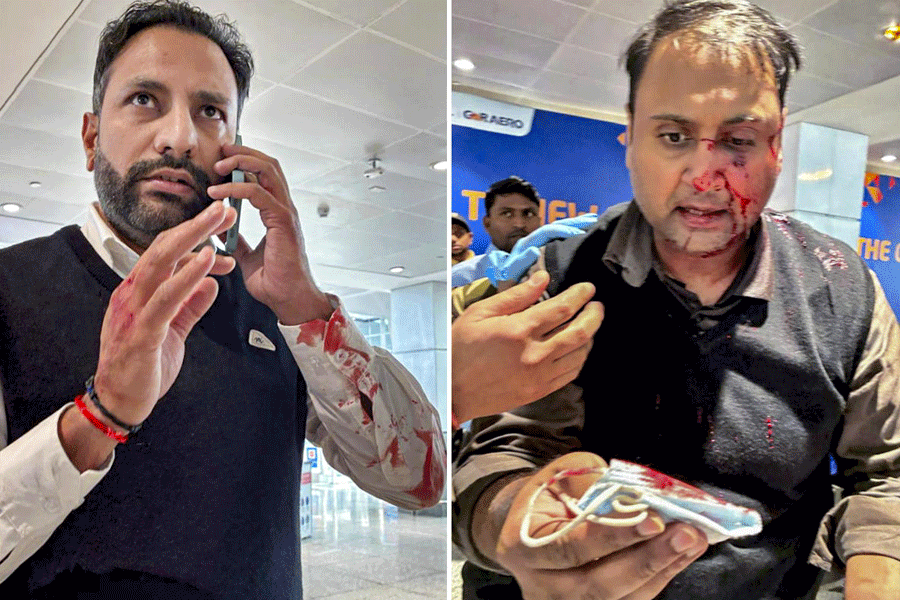 Passenger Ankit Dewan, right, bleeds after he was allegedly assaulted by off-duty Air India Express pilot Virender Sejwal, left, at Terminal 1 of Delhi airport.