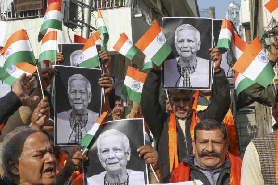 Shiv Sena members hold up portraits of Bangladesh chief adviser Muhammad Yunus during the protest in Jammu on Tuesday. 