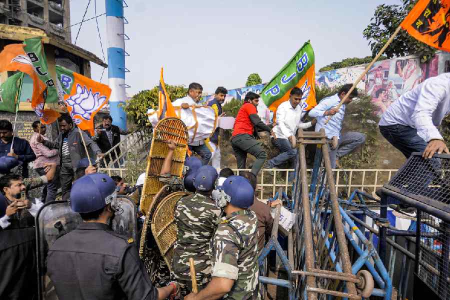Security personnel try to stop BJP supporters during a protest against the alleged killing of a Hindu youth in Bangladesh, near Howrah Bridge, Wednesday, Dec. 24, 2025.