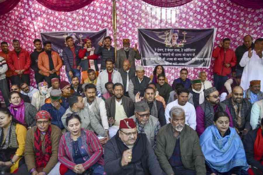 Congress leader Harish Rawat (centre) with traders protest against the murder in December 2022.
