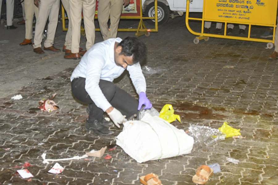 A police official investigates the site after a blast outside the Amba Vilas Palace, in Mysuru, Karnataka, Thursday, Dec. 25, 2025.