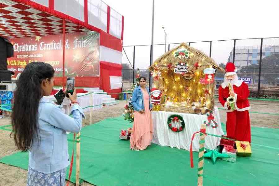 Visitors click pictures with the decorations and the robotic Santa Claus at the fair. 