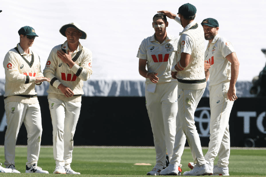 Australia's Scott Boland, third right, gets a pat on the head from teammate Mitch Starc after Boland bowled out England's Jamie Smith during their Ashes cricket test match in Melbourne, Friday, Dec. 26, 2025.