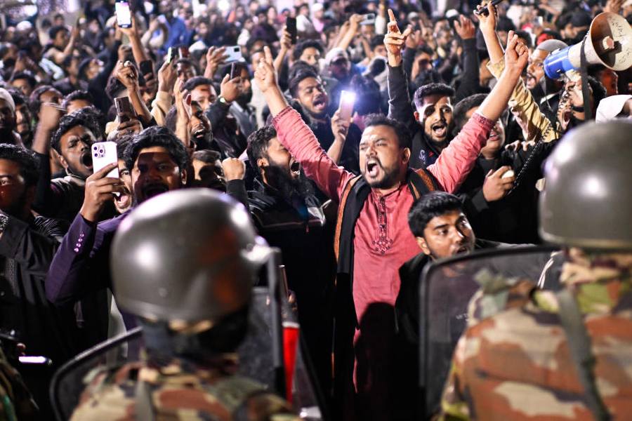 Protesters shout slogans in front of the premises of the Prothom Alo newspaper after news reached the country from Singapore of the death of a prominent activist Sharif Osman Hadi, in Dhaka, Bangladesh, Friday, Dec. 19, 2025.