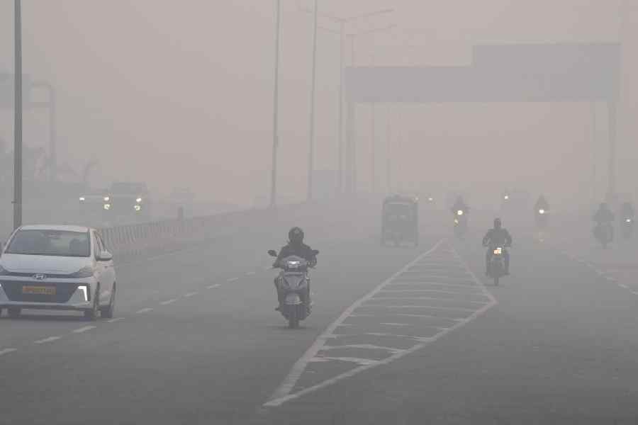 Commuters make their way amid dense smog, with hazy conditions reducing visibility on a winter morning, in New Delhi, Sunday, Dec. 28, 2025.