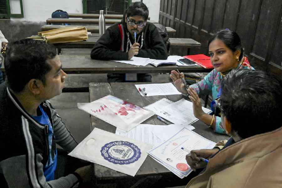 A booth level officer assists people during a hearing under the Special Intensive Revision (SIR) of electoral rolls, in Kolkata, West Bengal