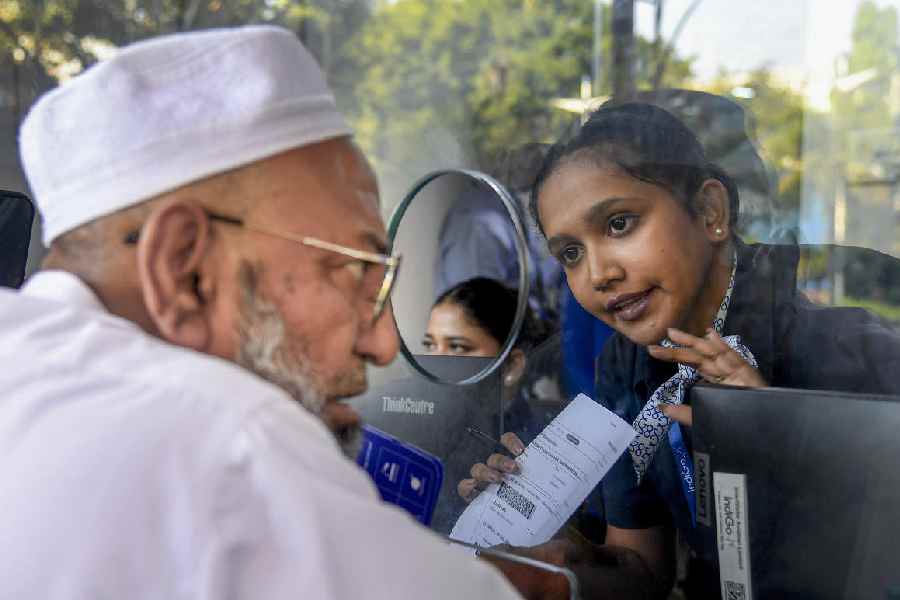 An IndiGo staff member speaks to a passenger amid flight disruptions at Mumbai airport on December 7.