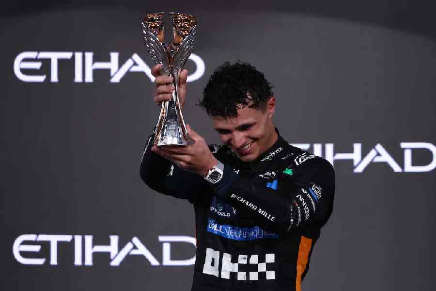 Lando Norris celebrates on the podium with the trophy after becoming the 2025 Formula One World Champion