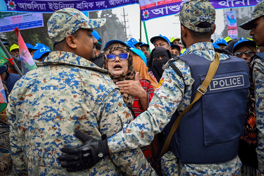 Police officers stand guard as supporters of Bangladesh Nationalist Party (BNP) acting chairman Tarique Rahman gather outside the National Martyrs' Memorial before his arrival in Savar, on the outskirts of Dhaka, Bangladesh, December 26, 2025.